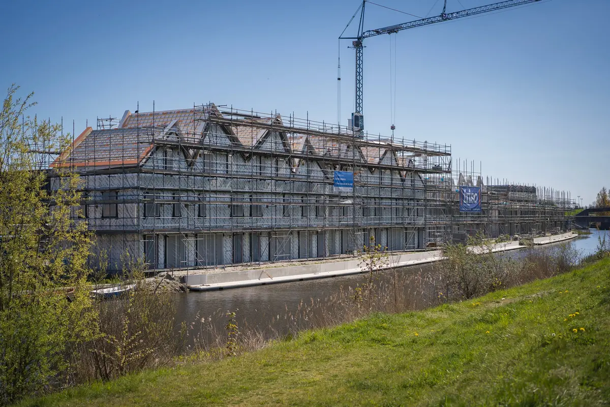 nieuwbouwproject aan het water in friesland, in de steigers met een bouwkraan.