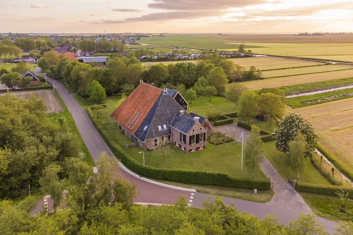 Luchtfoto van een woonwijk aan een Fries vaarwater met aangemeerde zeilboten